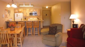 A compact living space with a kitchen, dining area, and a small seating area. - Charming Condo with Mountain Rustic Decor (Whitefish)