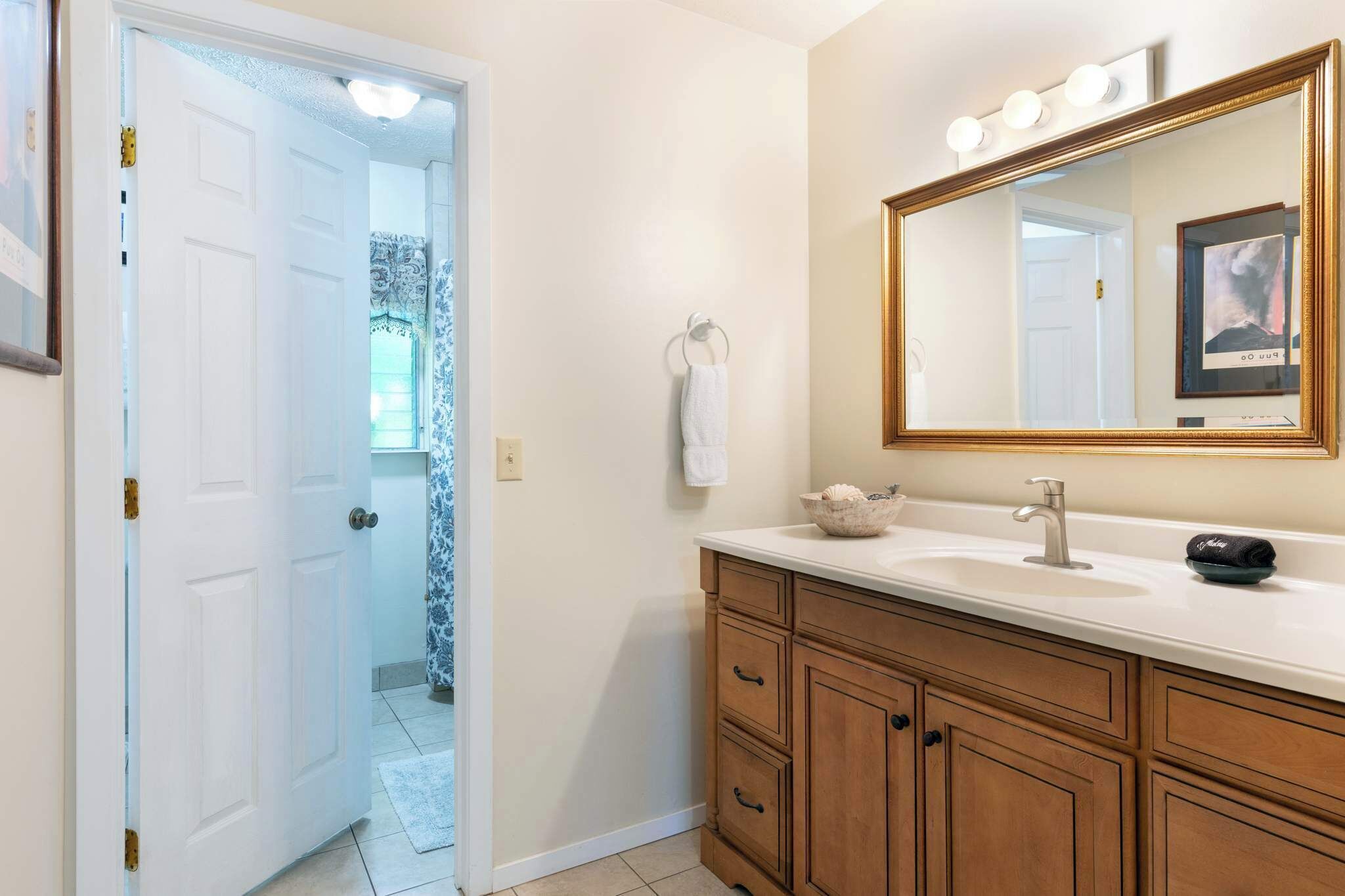 Une salle de bain avec une porte blanche, un lavabo avec un miroir et un porte-serviettes.