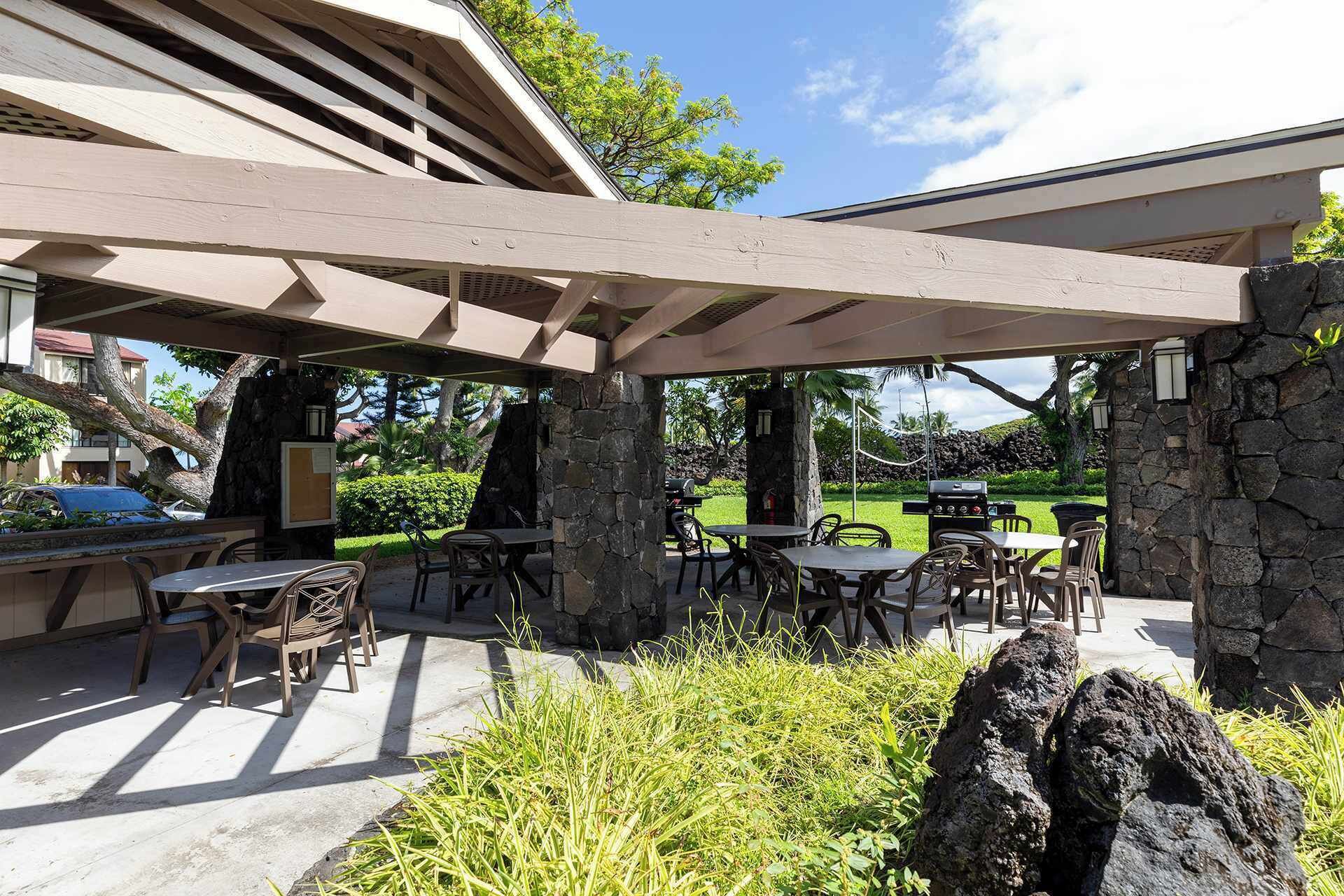 An outdoor patio area with stone pillars, tables, and chairs.
