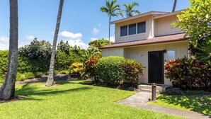 A two-story house with a well-maintained lawn and tropical plants. - Surf & Racquet Club #24 New Beds, New You! (Kailua-Kona)