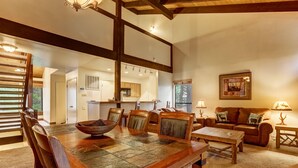 A spacious living room with a wooden dining table, leather chairs, a sofa, and a fireplace. - Whiskey Rock (South Lake Tahoe)
