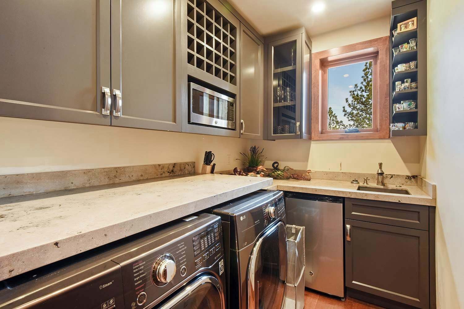 A modern kitchen with stainless steel appliances, a built-in oven, and a window above the sink.