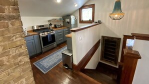 A compact kitchen with modern appliances, a wooden counter, and a hanging light fixture. - Cozy Cool Apartment on 6th Street!
WALK TO ACL FEST! (Austin)