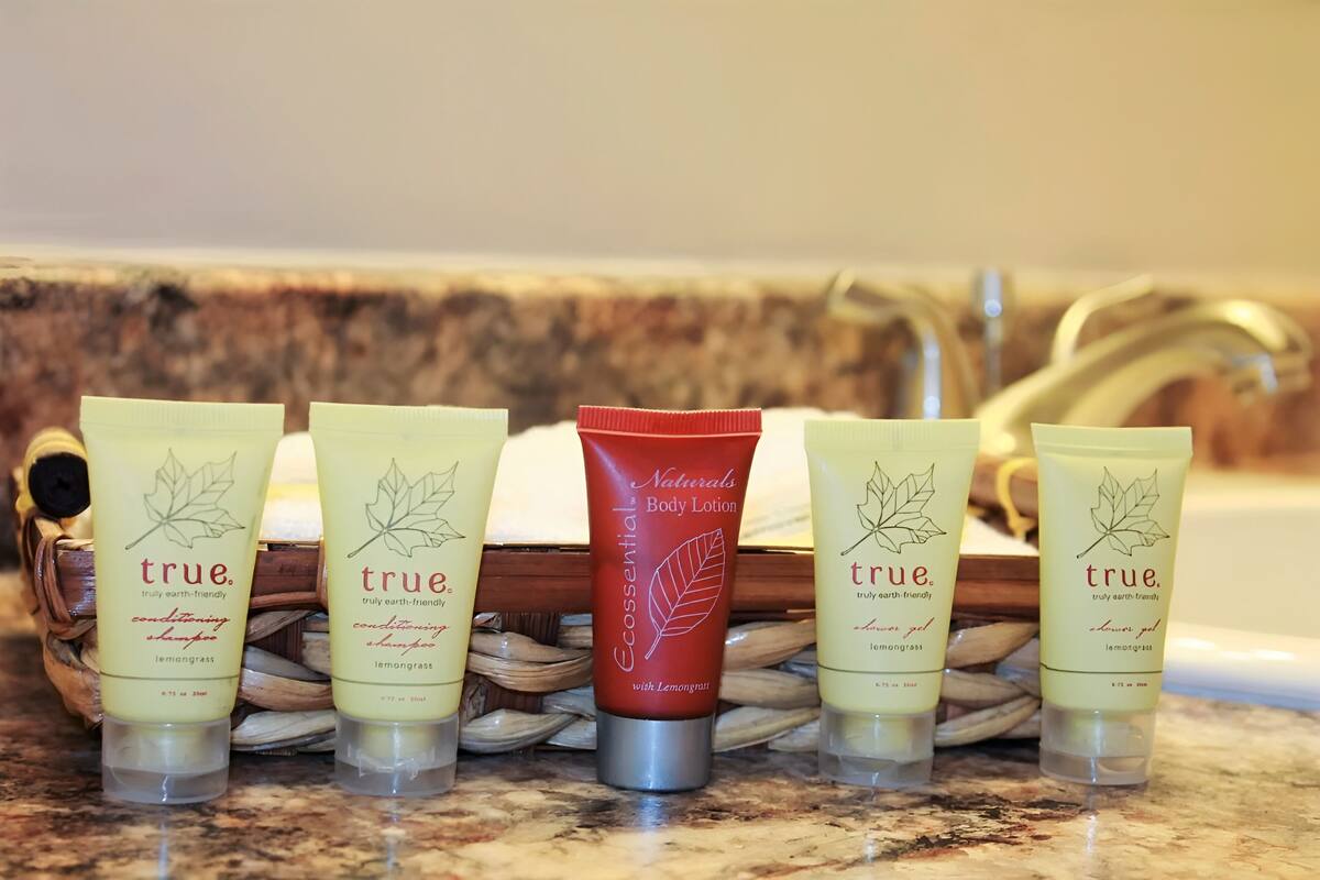 A set of five toiletries on a marble countertop.