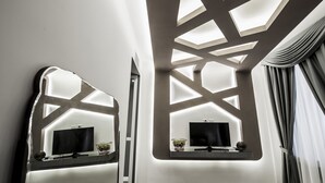 A modern bathroom with a large mirror, a television, and a window with curtains. - Spagna Boutique Luxury Suites (Rome)