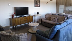 A living room with a television, sofa, and a small round table. - La Carrascala rural house 2 (Villaseco del Pan)
