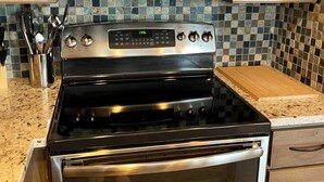 Eine Küche mit Edelstahlgeräten, darunter eine Mikrowelle und ein Backofen, sowie Holzausstattung.