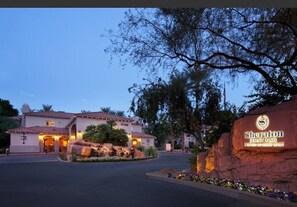 Experience the charm of Mediterranean-style architecture at Sheraton Desert Oasis, surrounded by beautifully landscaped gardens and a striking rock formation.
