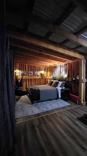 A rustic wooden room with a bed, a hanging chair, and a small table. - GlampVentures "Cedar Suncatcher" @river/lake near Smoky Mtns  (Newport)