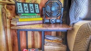 Una estantería de madera con libros, un ventilador y fichas de póker.