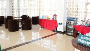 A hotel lobby with seating areas, a buffet table, and a vending machine. - Shell Suzhou Yongqiao District Dongchang Road National Purchase Square Hotel (Suzhou)