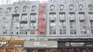 A multi-story hotel with a modern facade, multiple balconies, and air conditioning units. - Shell Suzhou Yongqiao District Dongchang Road National Purchase Square Hotel (Suzhou)
