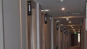 A modern hotel corridor with wooden paneling, numbered signs, and recessed lighting. - Shell Suzhou Yongqiao District Dongchang Road National Purchase Square Hotel (Suzhou)