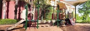 A playground with various equipment including slides, swings, and climbing structures.