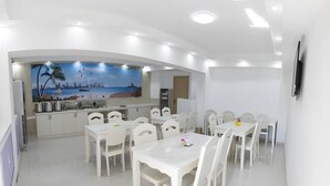Una cocina moderna con armarios blancos y un mural de una playa.