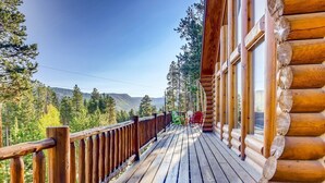 A wooden deck with a railing, overlooking a forested area with mountains in the distance. - Breck Cabin/ Mins from Town & Lifts/ Hot Tub (Breckenridge)