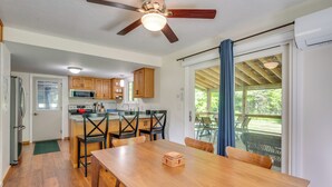 Cocina con armarios de madera, una mesa de comedor y un ventilador de techo.