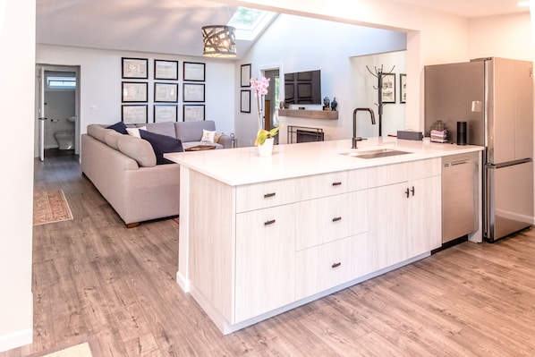 A modern kitchen with a central island, a built-in oven, and a refrigerator. - Cozy House perfect to enjoy the lake with Beach & Boat launch 2 minutes drive. (Lake Geneva)