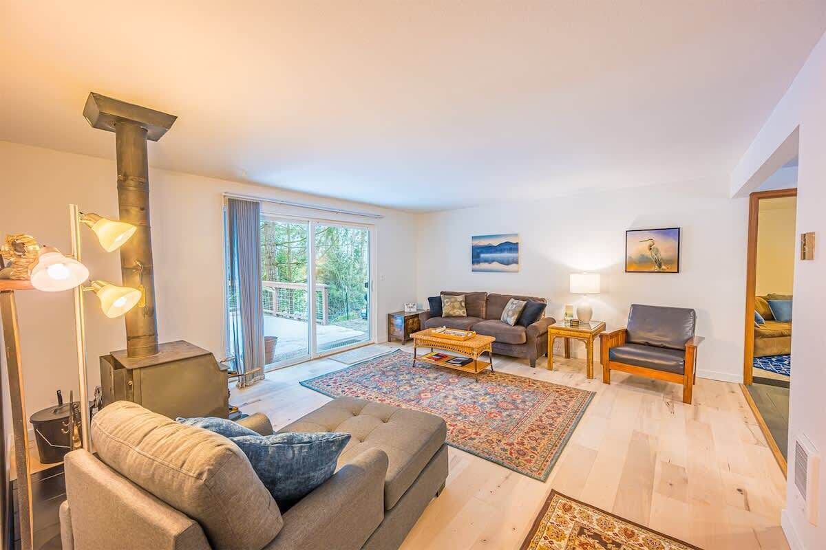 Ein modernes Wohnzimmer mit einer Couch, Sesseln, einem Couchtisch und einem Kamin.