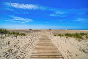 A wooden boardwalk leading to a sandy beach with sparse vegetation. - Sun-Soaked Wildwood Getaway, 6 Mi to Cape May! (Wildwood Crest)