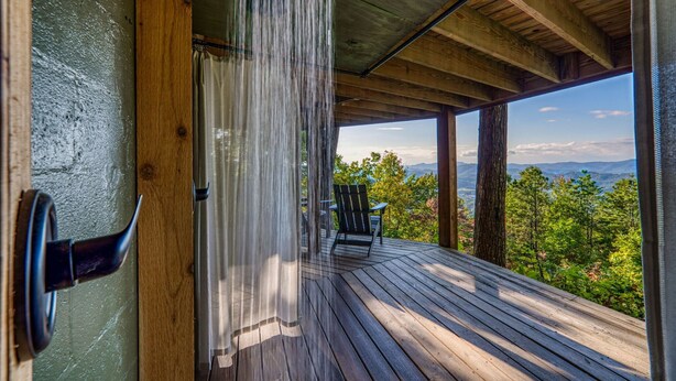 Une terrasse en bois offrant une vue sur un paysage boisé.