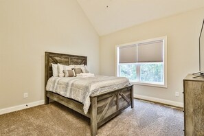 A bedroom with a bed, a window, and a desk. - Dream Ridge | Ellijay, GA (Ellijay)