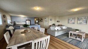 Un espace de vie compact comprenant un coin repas, une kitchenette et un ensemble de canapés.