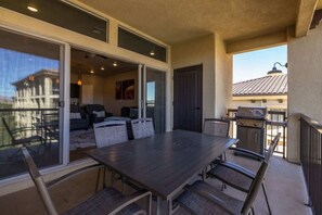 A balcony with a dining table, chairs, and a grill. - Estancia Pool Resort #S401 | Penthouse View (Saint George)