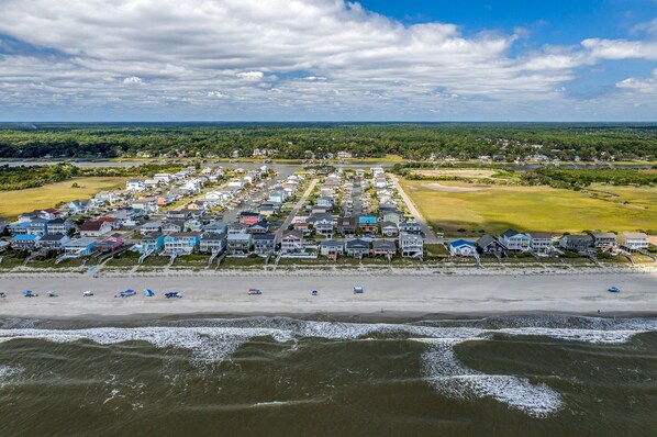 An aerial view of a coastal residential area with houses and a beach. - 'Pop's Inn" - Oceanfront Home, 4 Bedrooms / 2 Bathrooms (Holden Beach)