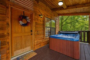 A wooden cabin with a door, a hot tub, and a deck. - Private Pond Views | Hot Tub Nights | Deck Coffee (Sevierville)