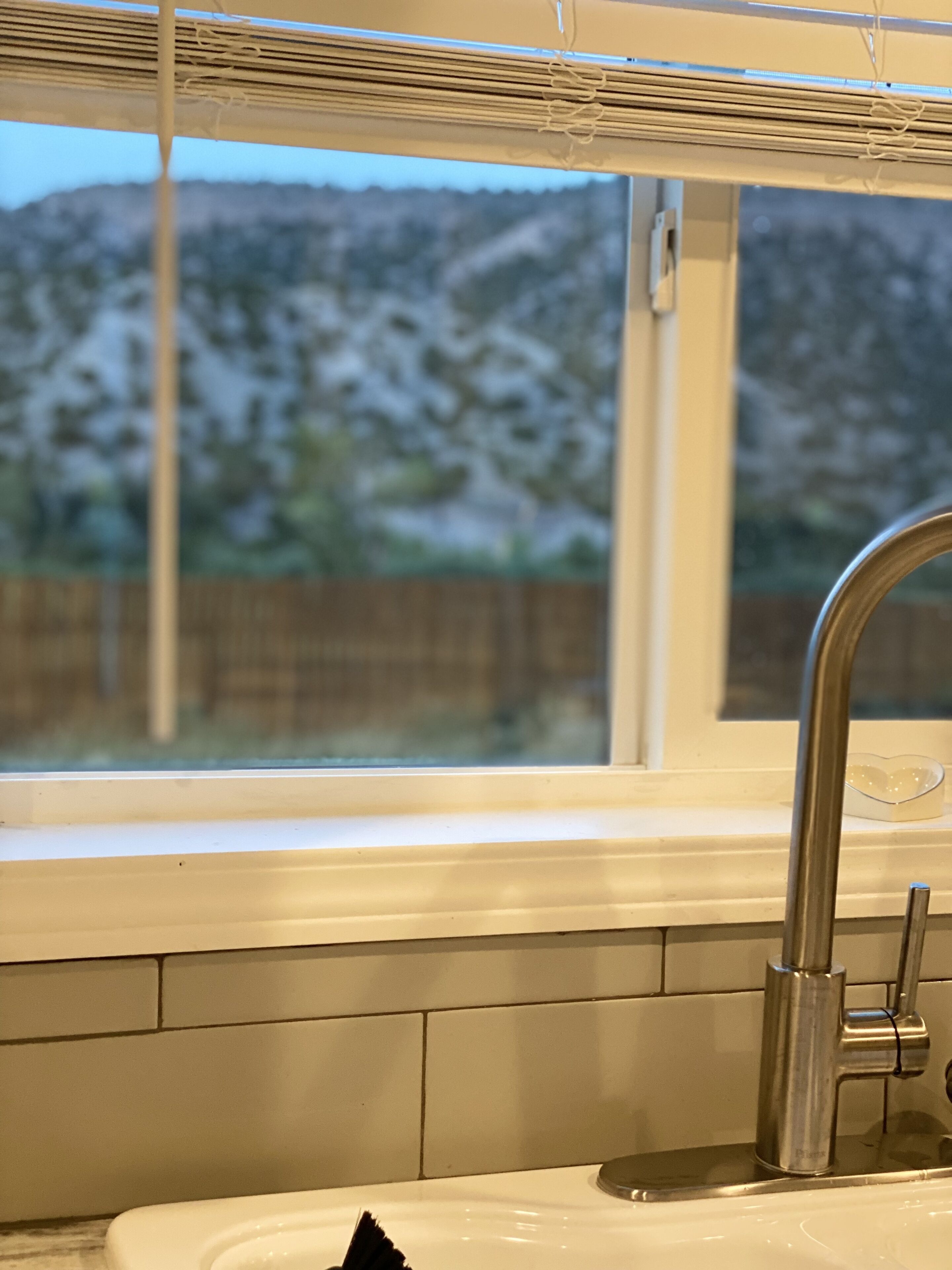 Ein Badezimmer mit Waschbecken, Spiegel und Fenster.