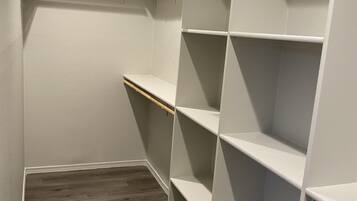 A walk-in closet with wooden shelves and a wooden floor.