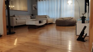 A modern living room with a sofa, a bean bag, a coffee table, and a floor lamp.