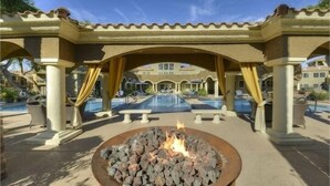A pool area with a fire pit, outdoor seating, and a covered walkway. - 7 Bedroom / 6 Bath Condos at TPC Scottsdale (Scottsdale)