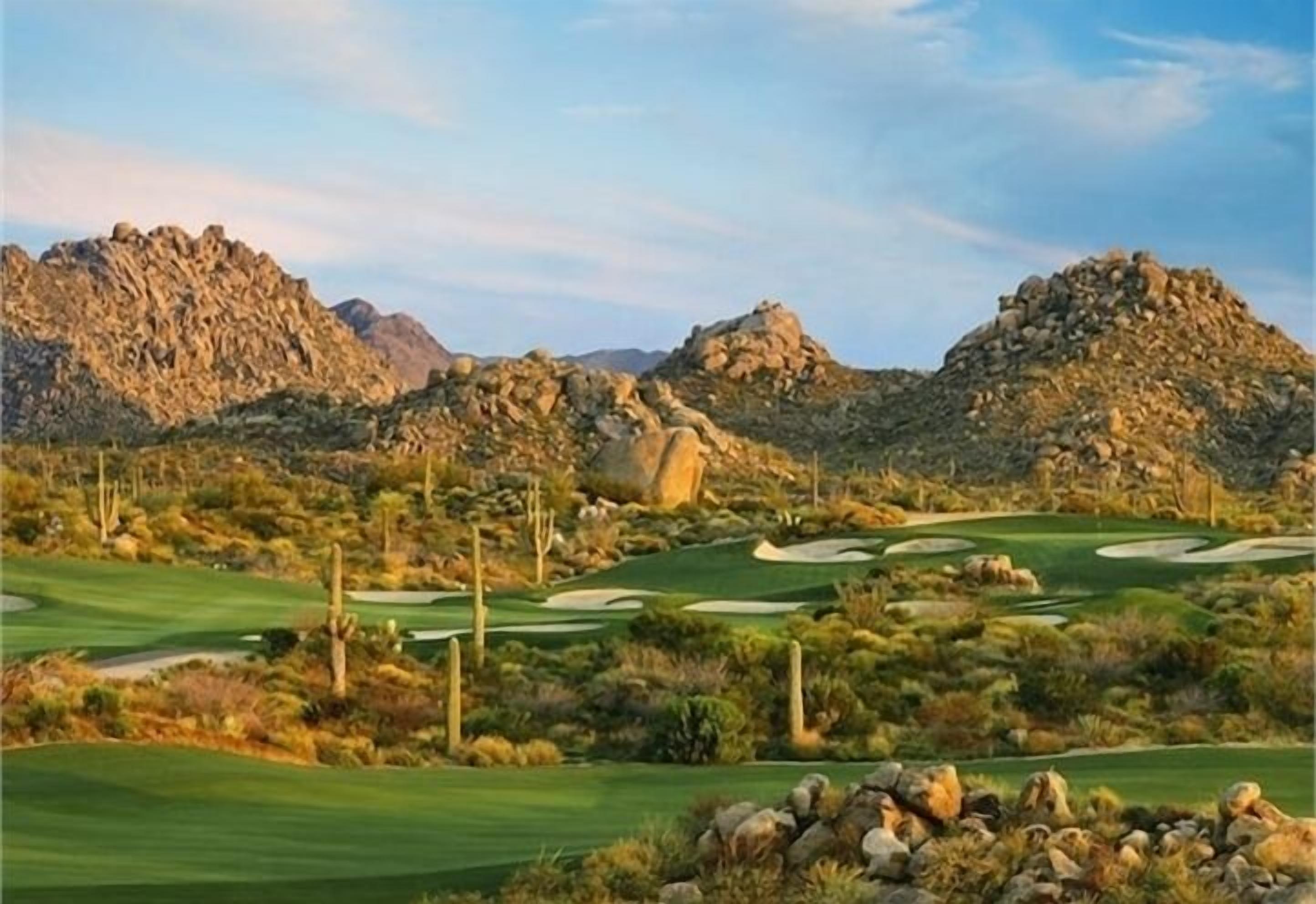 Un campo de golf en el desierto con terreno pedregoso y vegetación escasa.