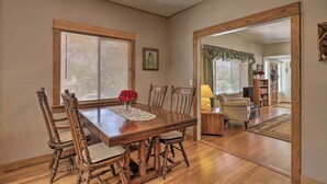 A dining area with a wooden table and chairs, a vase with red flowers, and a ceiling fan. - Lots of Parking & Only 2 Steps Into the Back Door! (Bisbee)