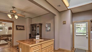 A spacious living room with a wooden coffee table, a ceiling fan, and a large window. - Lots of Parking & Only 2 Steps Into the Back Door! (Bisbee)
