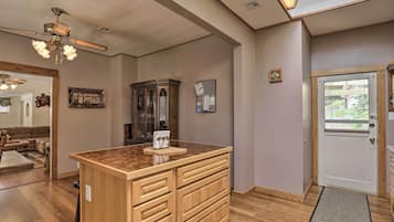 Un salon spacieux avec une table basse en bois, un ventilateur de plafond et une grande fenêtre.
