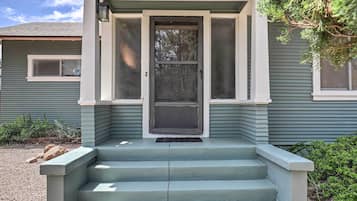 Une maison avec un porche à l’avant, une porte dotée d’un panneau de verre et une petite fenêtre située au-dessus de la porte.