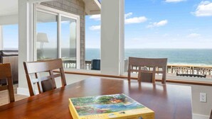 A dining area with a table, chairs, and a view of the ocean. - Stunning Panoramic Ocean Front Views, Single Level, Open Floor Plan, BBQ, Large Deck, Walk to Beach (Cloverdale)