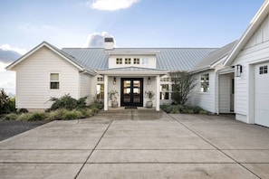 A two-story house with a front porch, a garage, and a driveway.