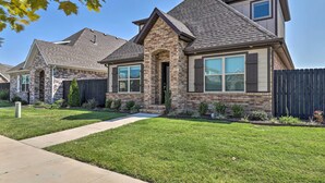 A two-story house with a brick facade, a stone chimney, and a well-maintained lawn. - Fayetteville House: Pool Access & Gas Grill! (Fayetteville)