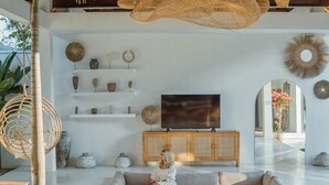 Un salon moderne avec une table en bois, un canapé et un téléviseur.