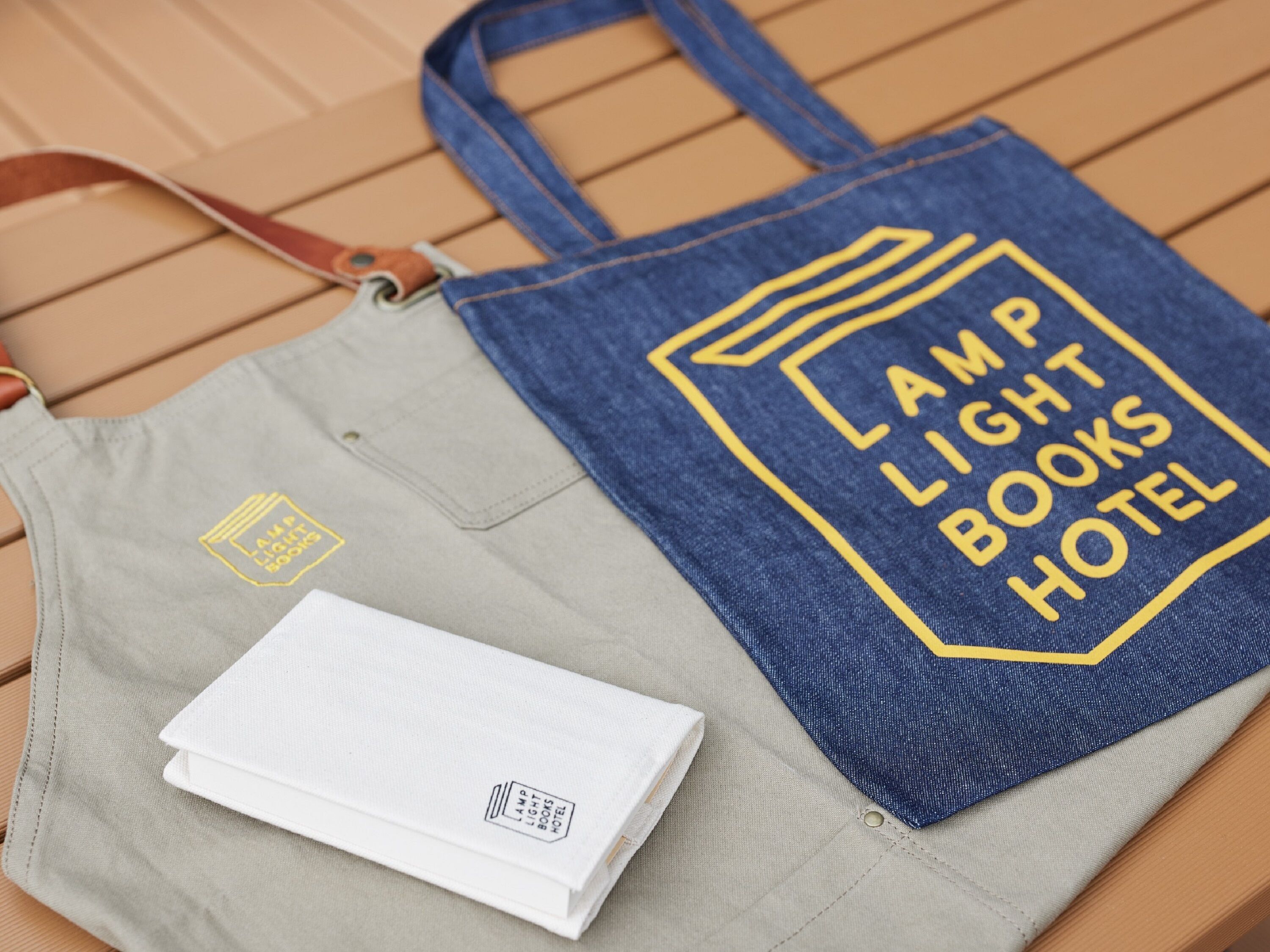 Eine graublå tote Bag mit dem Aufdruck "AMP LIGHT BOOKS HOTEL".