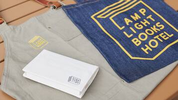 Eine graublå tote Bag mit dem Aufdruck "AMP LIGHT BOOKS HOTEL".