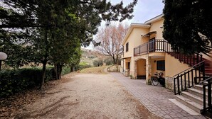 A building with a stone staircase, a balcony, and a gravel driveway. - Country House near Rome (Castel Madama)