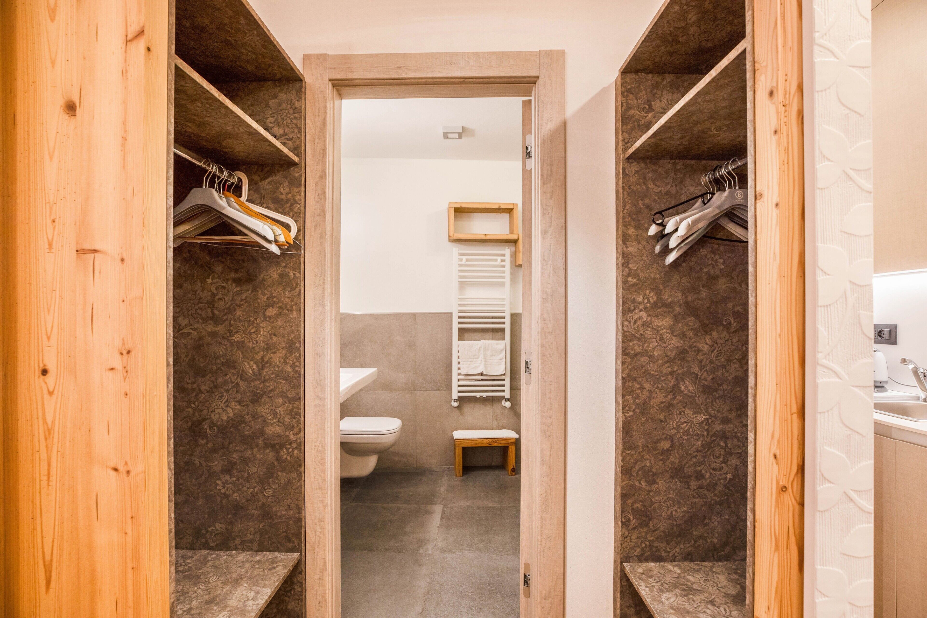 Une salle de bain équipée de toilettes, d’un banc et d’un porte-serviettes.