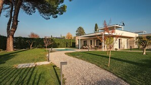 A modern house with a swimming pool, a well-maintained lawn, and a clear sky. - Holiday Home "Lagolino Boutiquehouse " with Pool, Garden & Wi-Fi (Pacengo/Lazise)