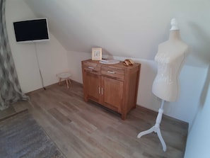 A room with a wooden cabinet, a small stool, a white mannequin, and a flat-screen TV mounted on the wall. - 3-room vacation home (6 persons) Luv - Holiday homes Luv and Lee OVS 106 with sauna (Zierow)