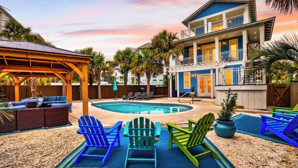 A pool area with Adirondack chairs, a covered seating area, and a two-story building with balconies.
